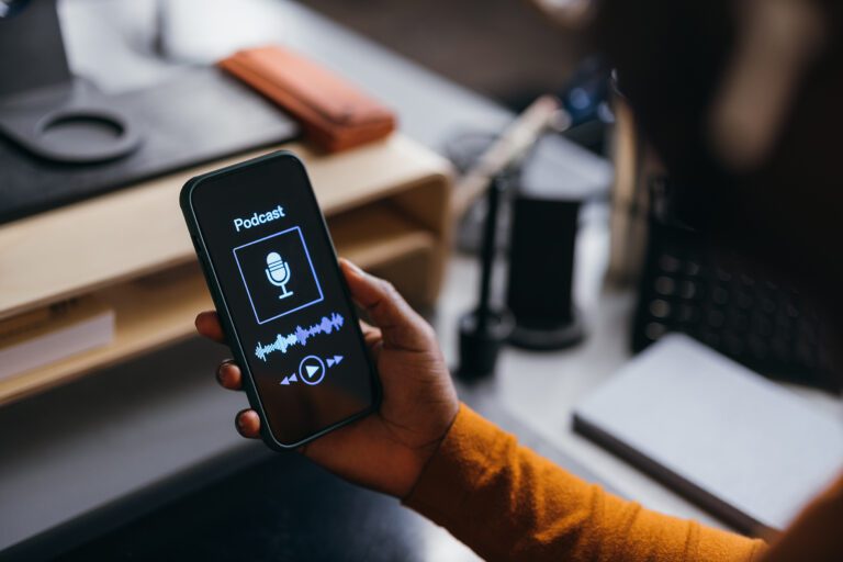 A Cropped Photo Of An Unrecognizable Businessman Playing Some Podcast Using His Mobile Phone